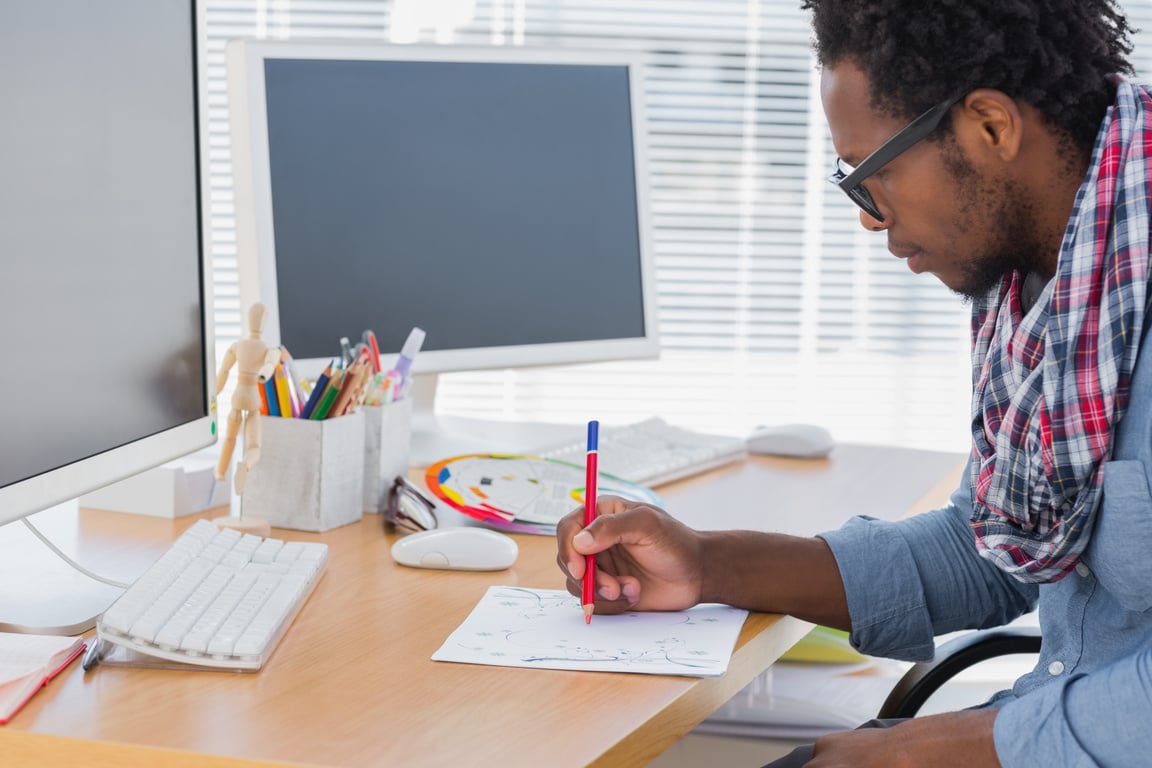 Handsome designer drawing something with a red pencil